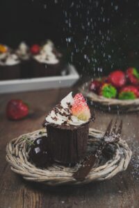 Chocolate cupcake with whipped cream and cherries